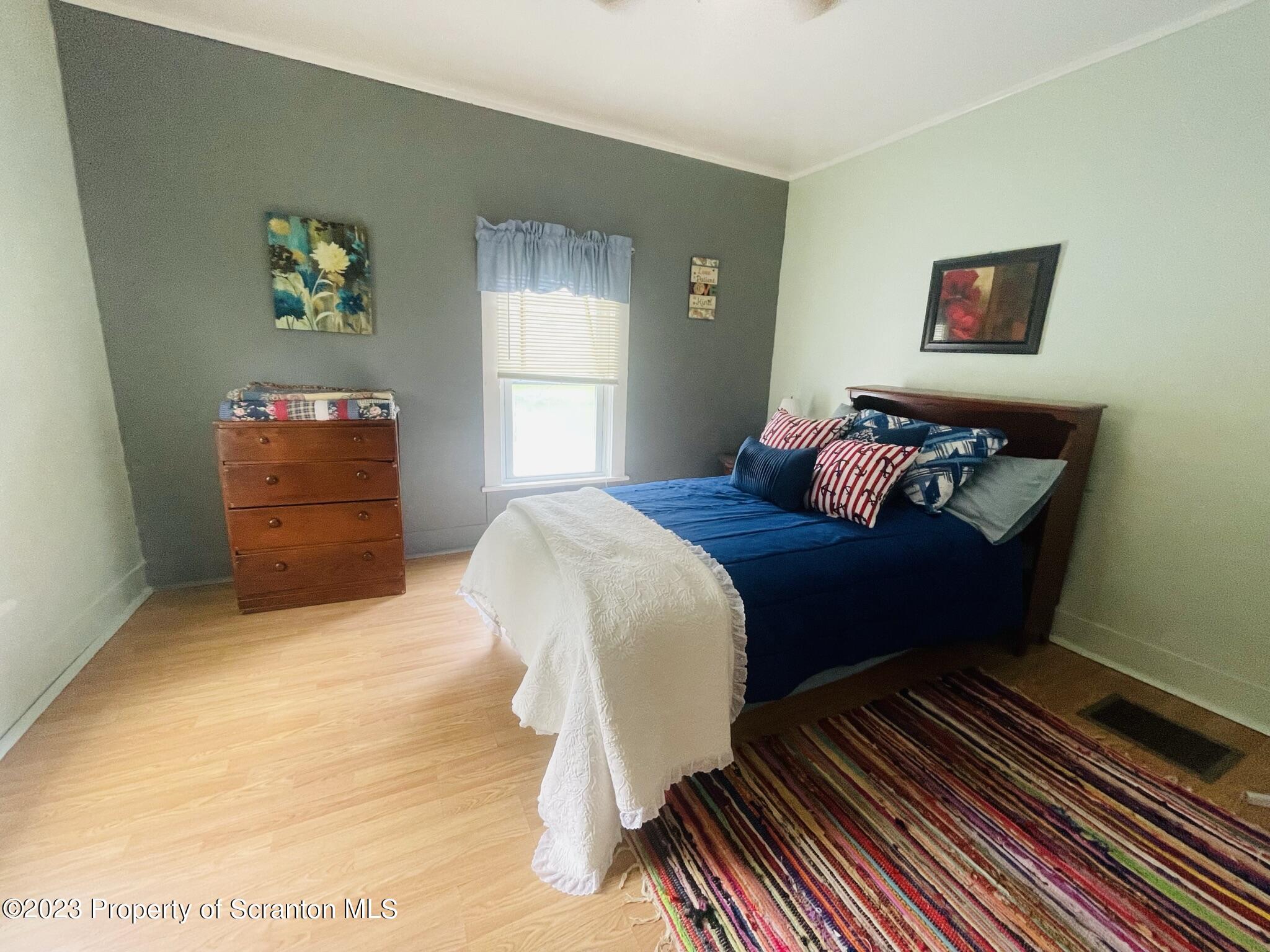 176 Stack Road Thompson, PA 18465 - Photo 21 of 53 a bedroom with a bed and wooden floor