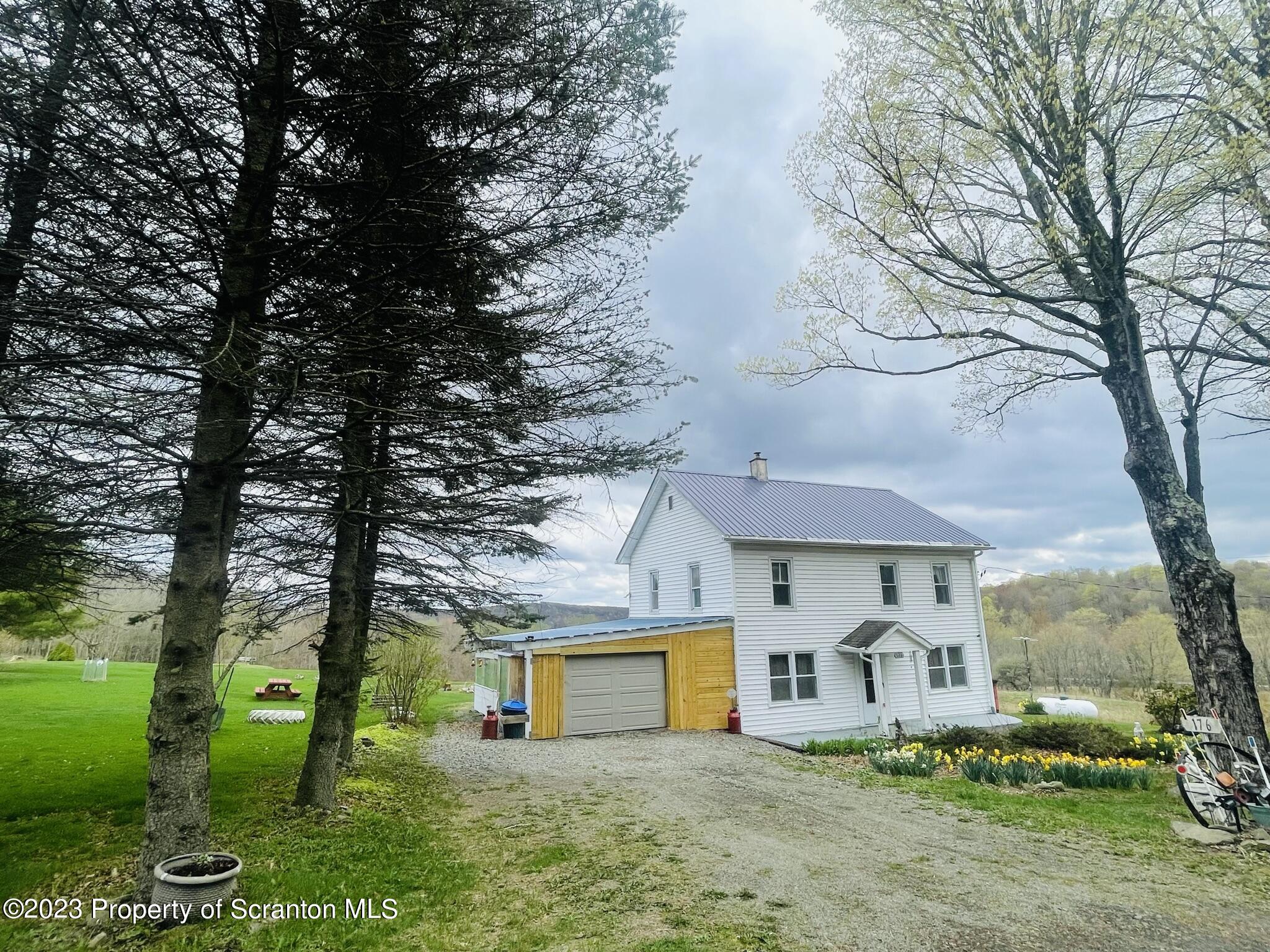 176 Stack Road Thompson, PA 18465 - Photo 30 of 53 a front view of a house with garden