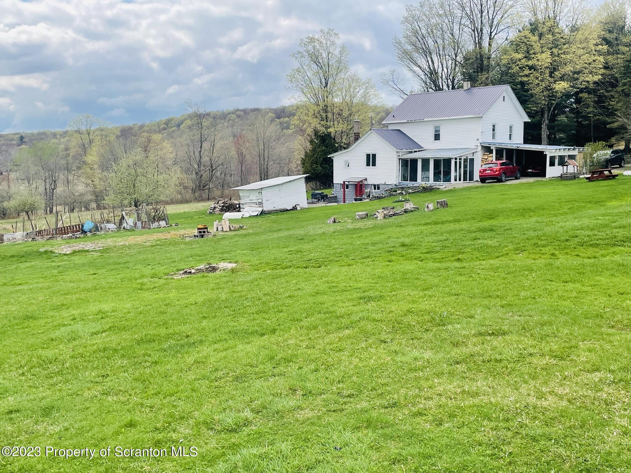176 Stack Road Thompson, PA 18465 - Photo 50 of 53 a view of a house with a big yard and large trees