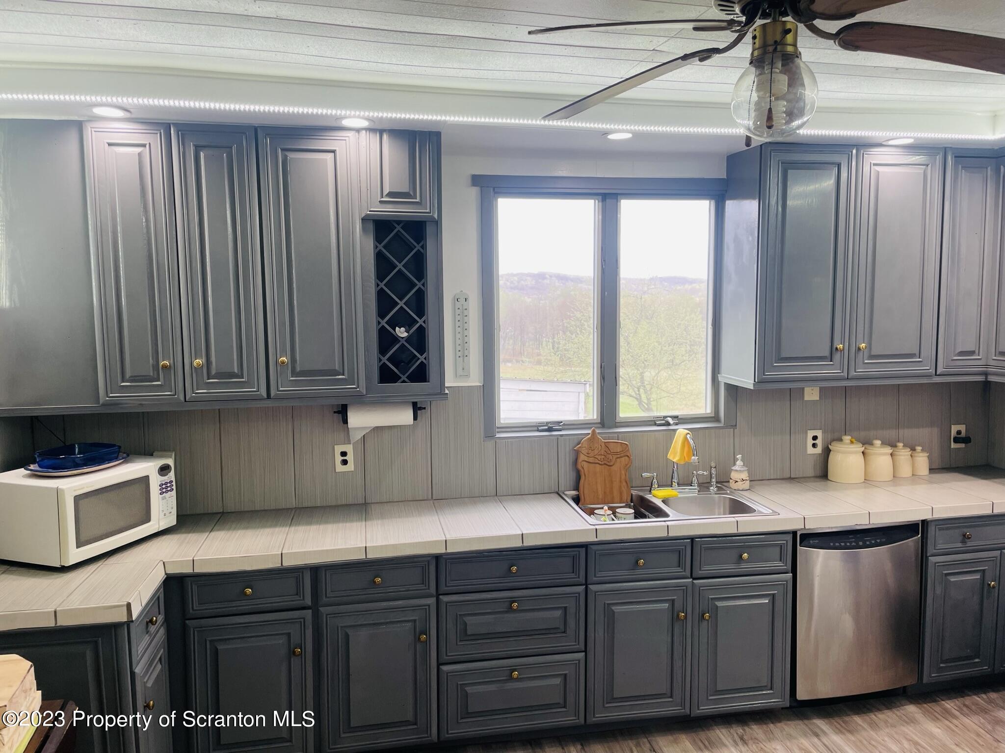 176 Stack Road Thompson, PA 18465 - Photo 8 of 53 a kitchen with stainless steel appliances granite countertop a sink a stove and cabinets