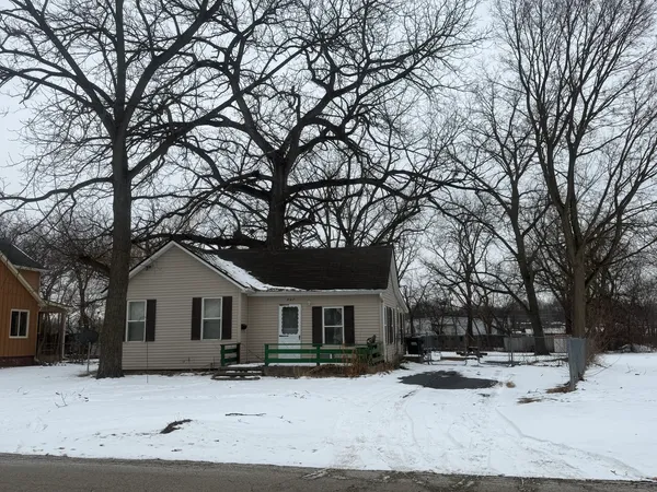 a front view of a house with a yard covered in snow