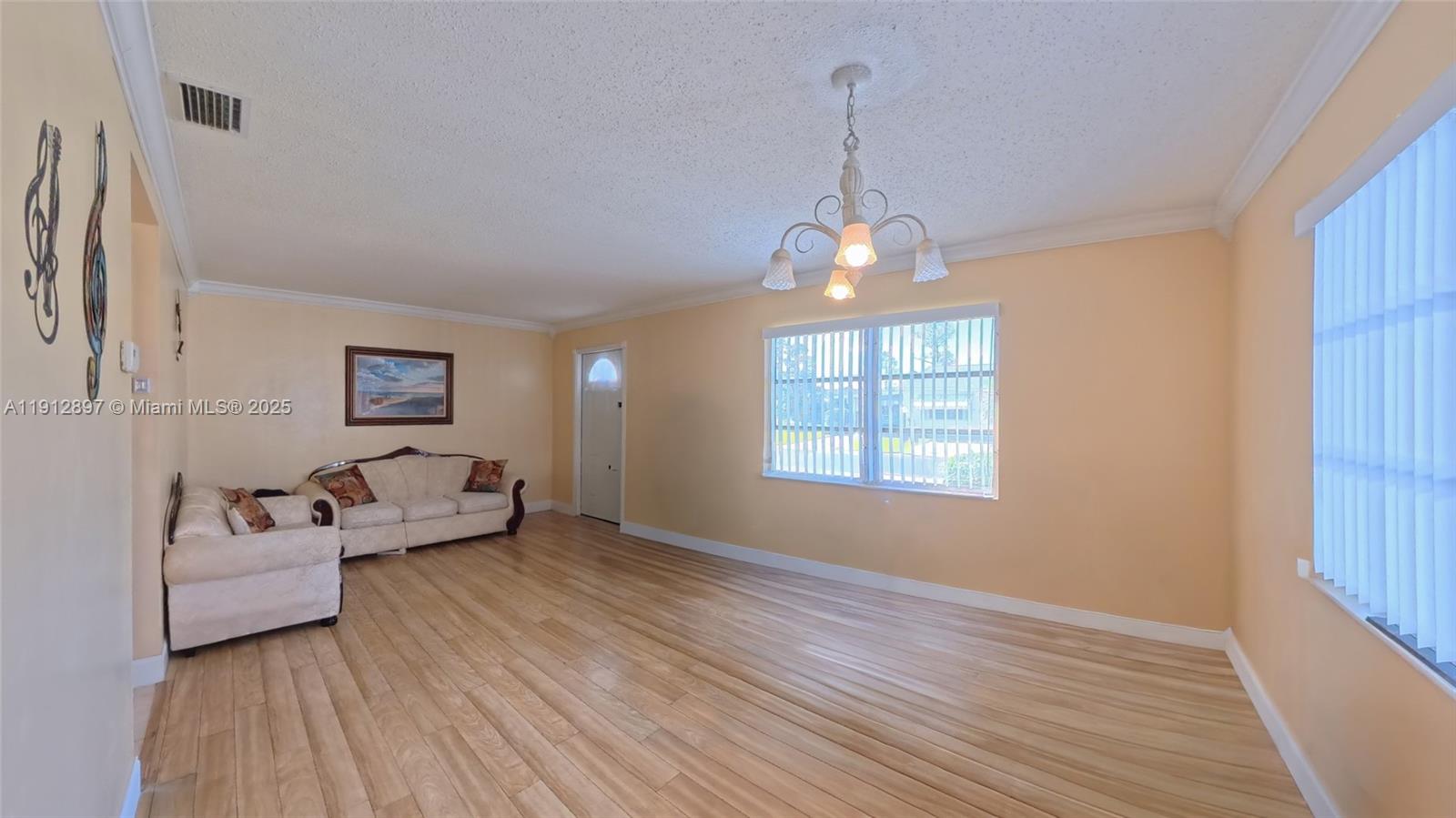 10 Dawn Flower Circle Lehigh Acres, FL 33936 - Photo 13 of 25 a living room with furniture and a chandelier