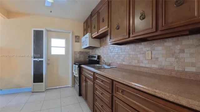 a kitchen with stainless steel appliances granite countertop a sink a stove and a refrigerator