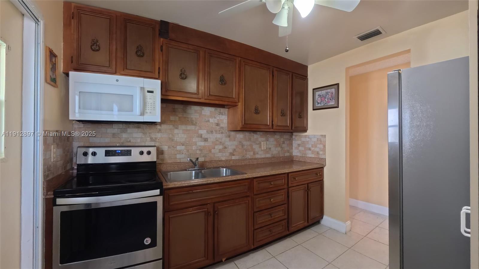 10 Dawn Flower Circle Lehigh Acres, FL 33936 - Photo 18 of 25 a kitchen with stainless steel appliances granite countertop a stove a refrigerator and a microwave