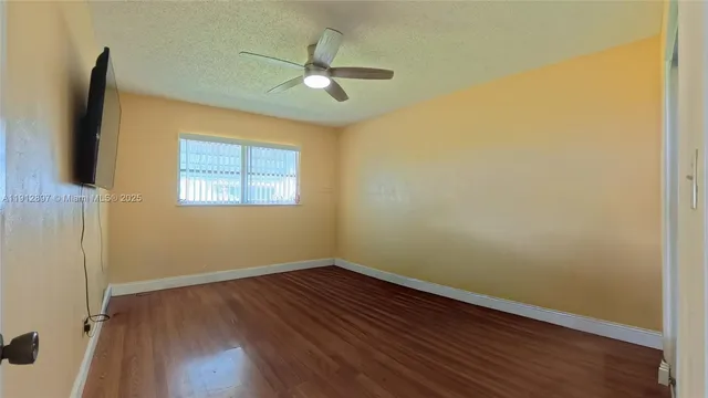 a view of a room with wooden floor and fan