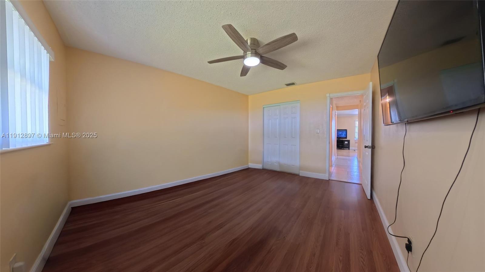 10 Dawn Flower Circle Lehigh Acres, FL 33936 - Photo 22 of 25 an empty room with wooden floor fan and windows