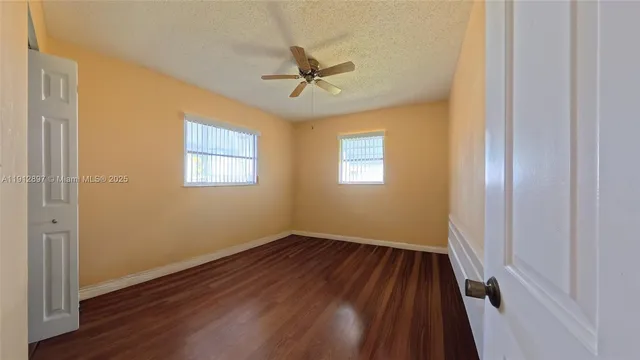 a view of a room with wooden floor a ceiling fan and closet