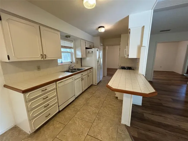 a kitchen with stainless steel appliances granite countertop a sink dishwasher stove refrigerator and cabinets
