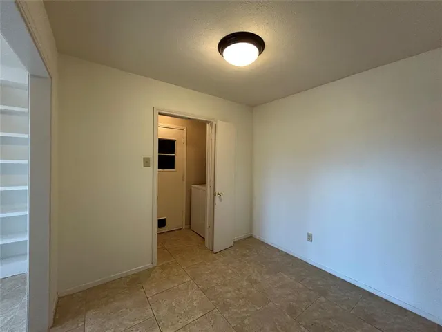 an empty room with closet and mirror