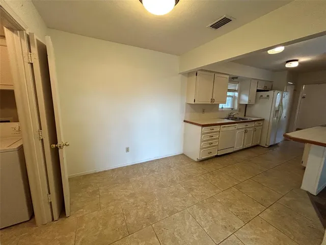 a room with granite countertop a sink and a stove top oven