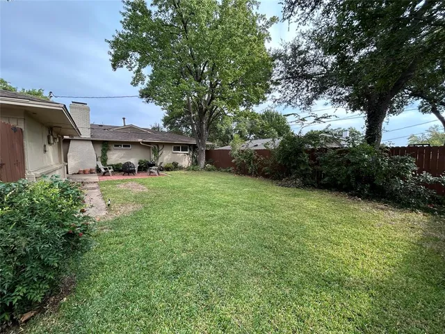 a view of a house with a yard balcony and tree