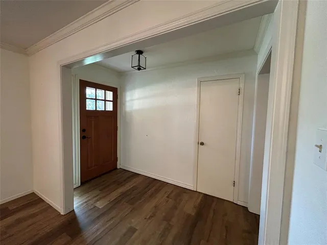 a view of hallway with window and wooden floor