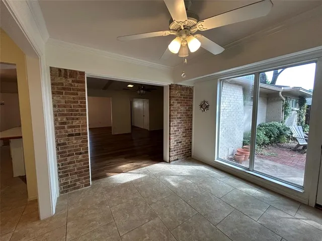 en empty room with windows and ceiling fan