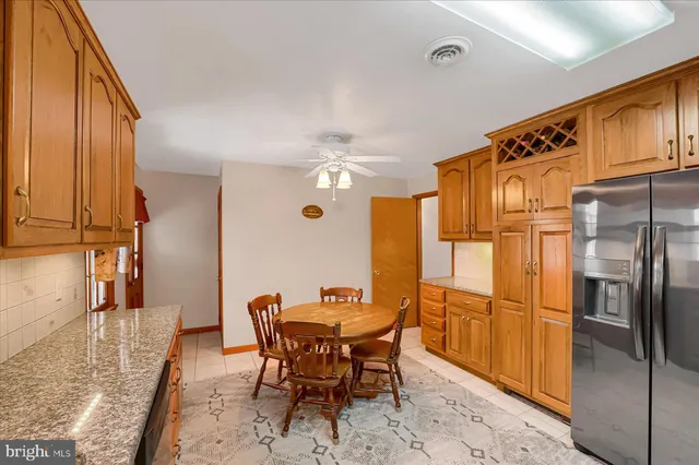 a dining room with stainless steel appliances granite countertop furniture a refrigerator and a kitchen view