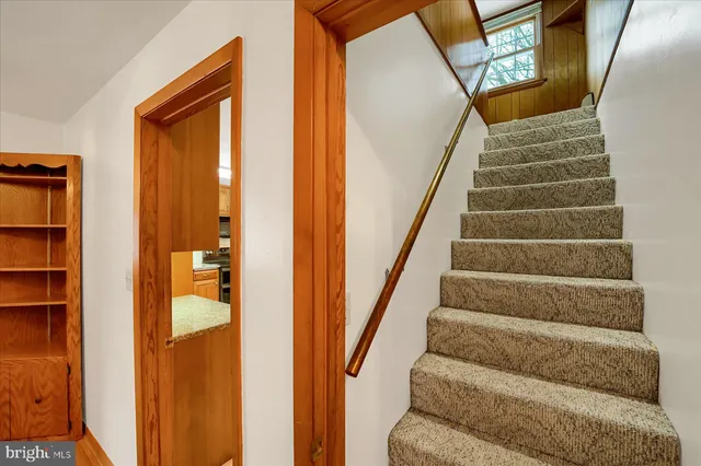 a view of staircase with white walls and railing