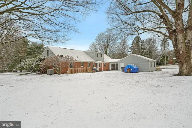a front view of house with large trees