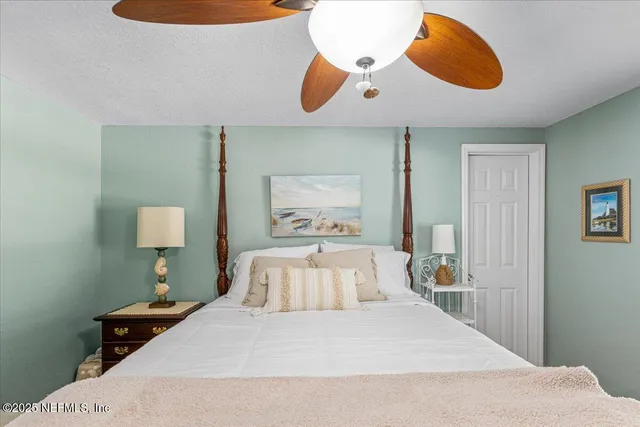 a bedroom with a bed and a painting on the wall