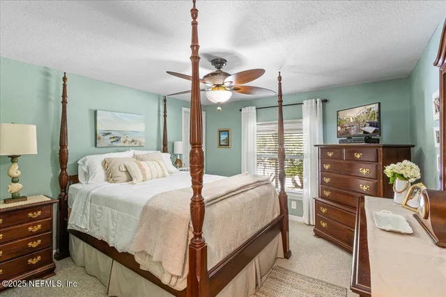 a bedroom with a bed a dresser and potted plants