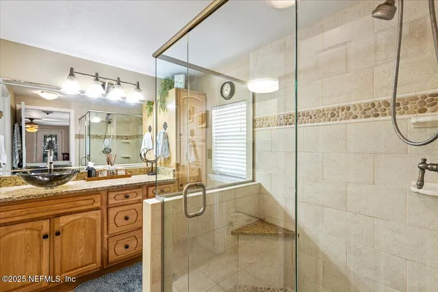 a bathroom with a granite countertop sink mirror and a shower
