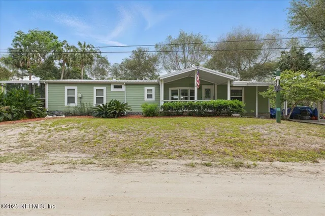 a front view of house with yard and trees around