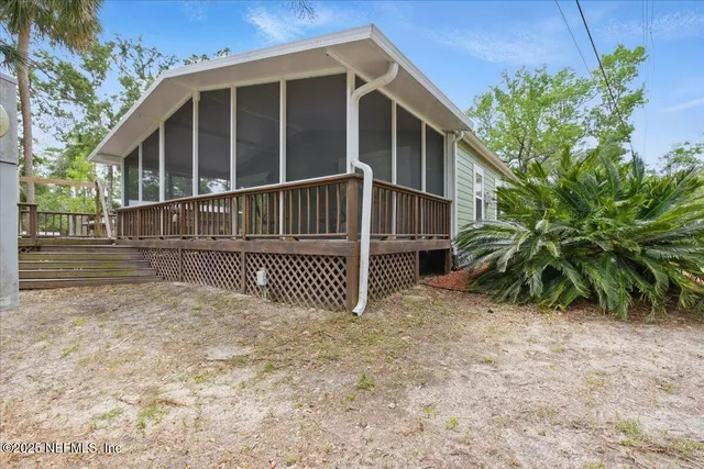 a view of a small house with wooden fence and plants