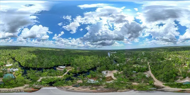 an aerial view of a house with a yard and tennis court