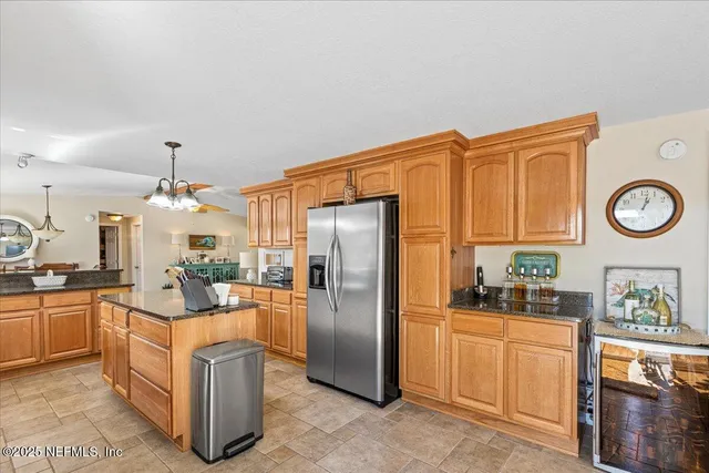 a kitchen with stainless steel appliances granite countertop a refrigerator a stove and a sink