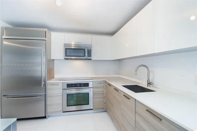 a kitchen with granite countertop a sink stove and refrigerator