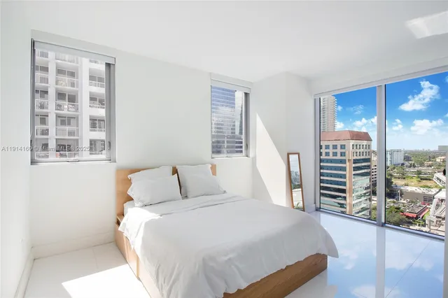 a bedroom with a bed and a large window