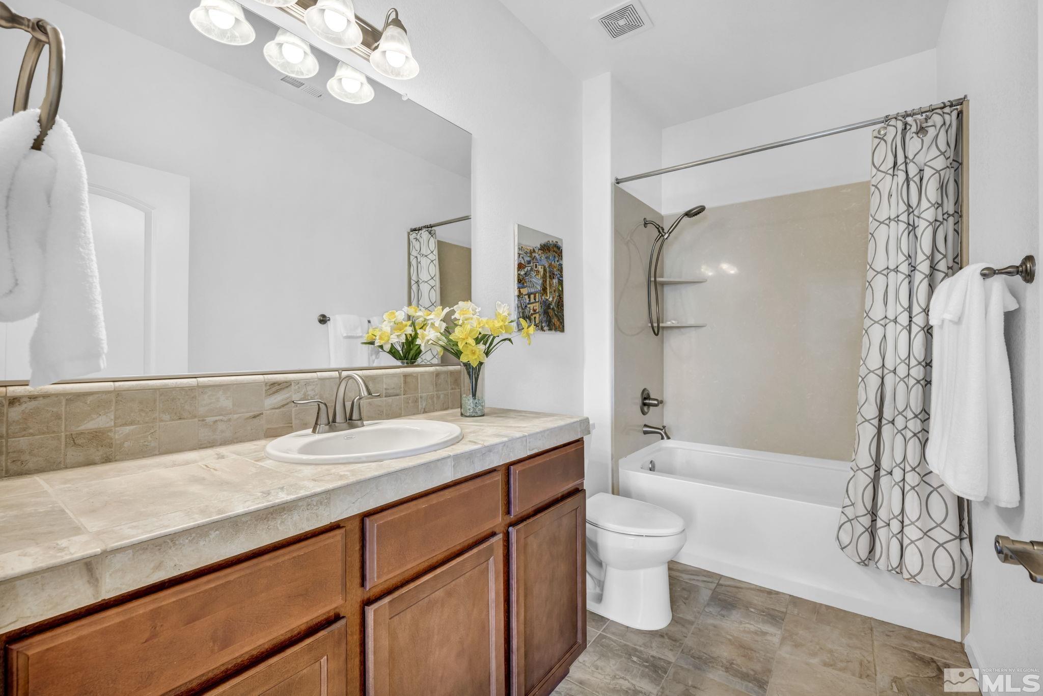 2197 Berkich Court Reno, NV 89521 - Photo 25 of 40 a bathroom with a granite countertop sink a toilet and shower