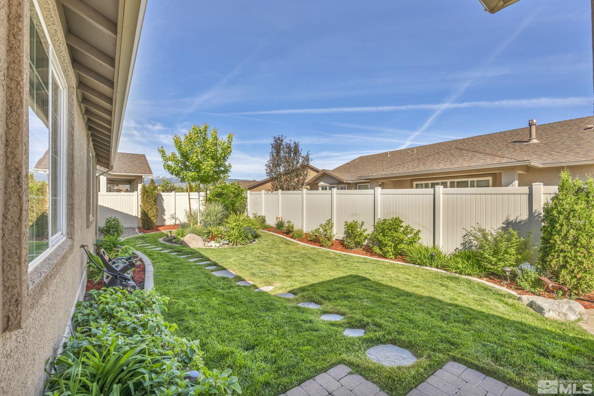 2197 Berkich Court Reno, NV 89521 - Photo 30 of 40 a view of a house with a yard and table and chair under an umbrella