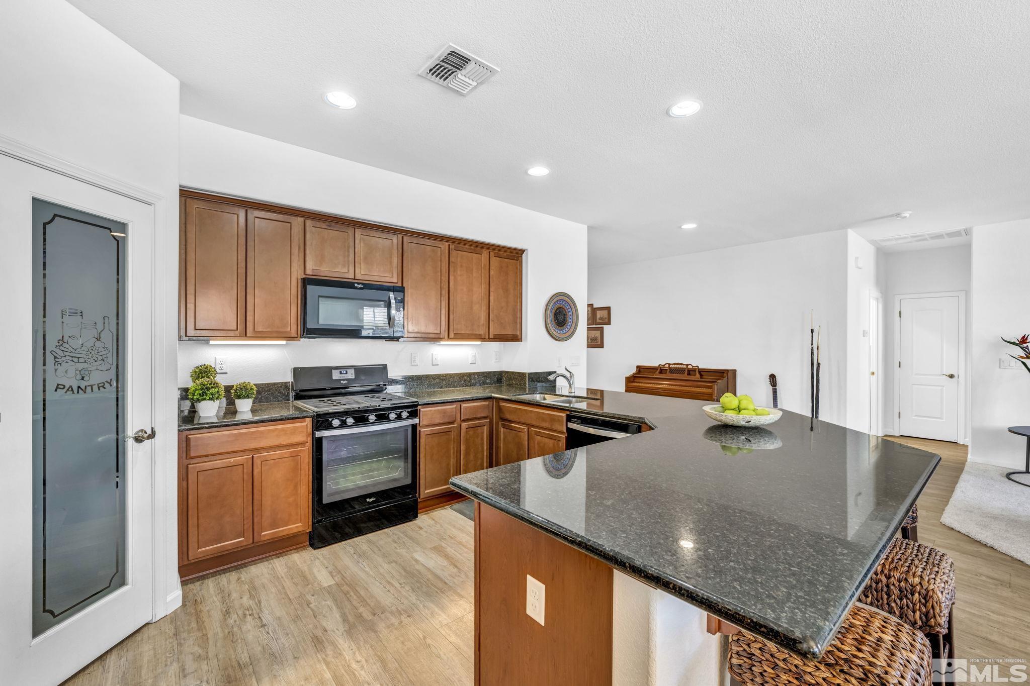 2197 Berkich Court Reno, NV 89521 - Photo 5 of 40 a kitchen with stainless steel appliances granite countertop a sink a stove top oven a counter space and cabinets