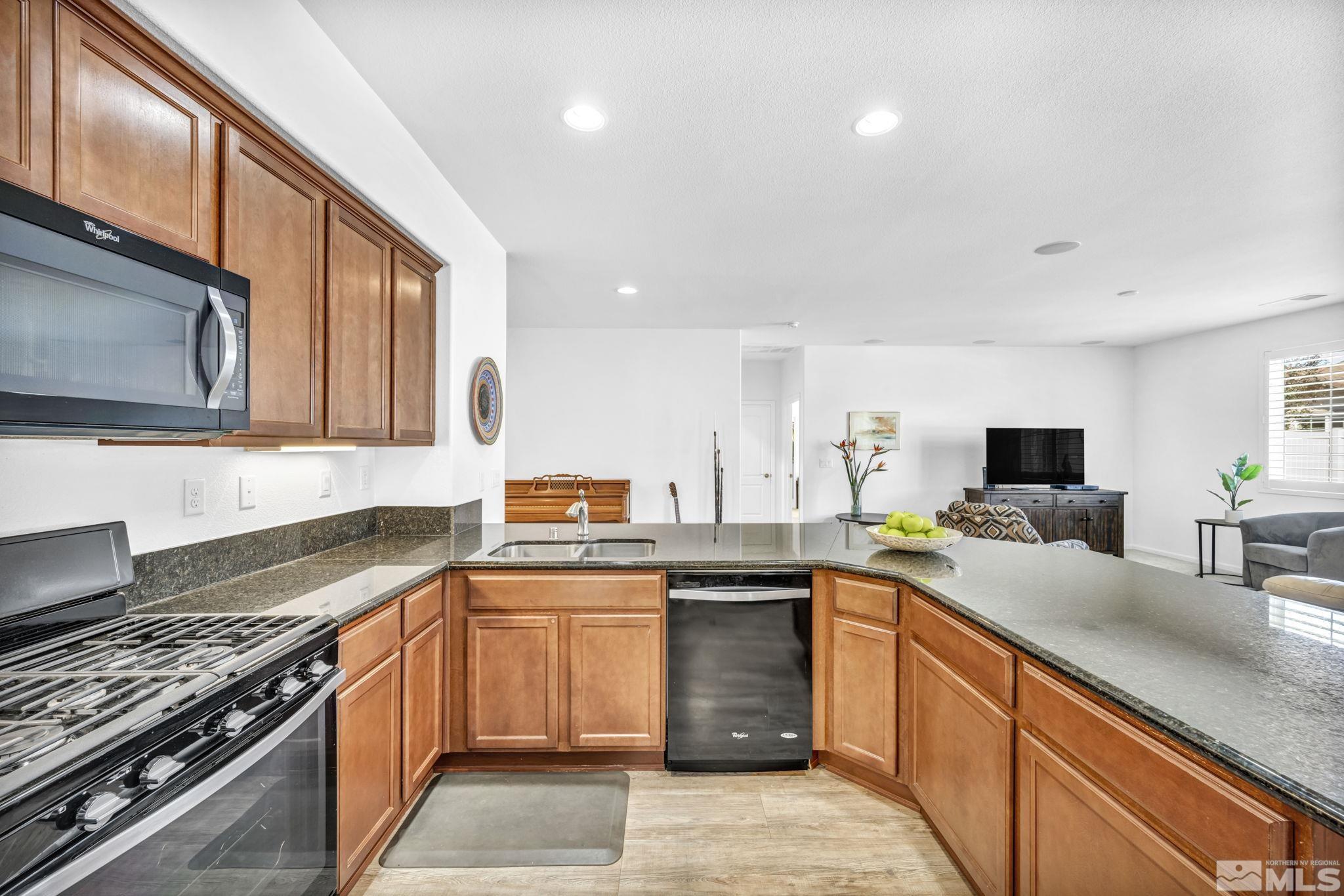2197 Berkich Court Reno, NV 89521 - Photo 7 of 40 a kitchen with stainless steel appliances granite countertop a sink stove and refrigerator