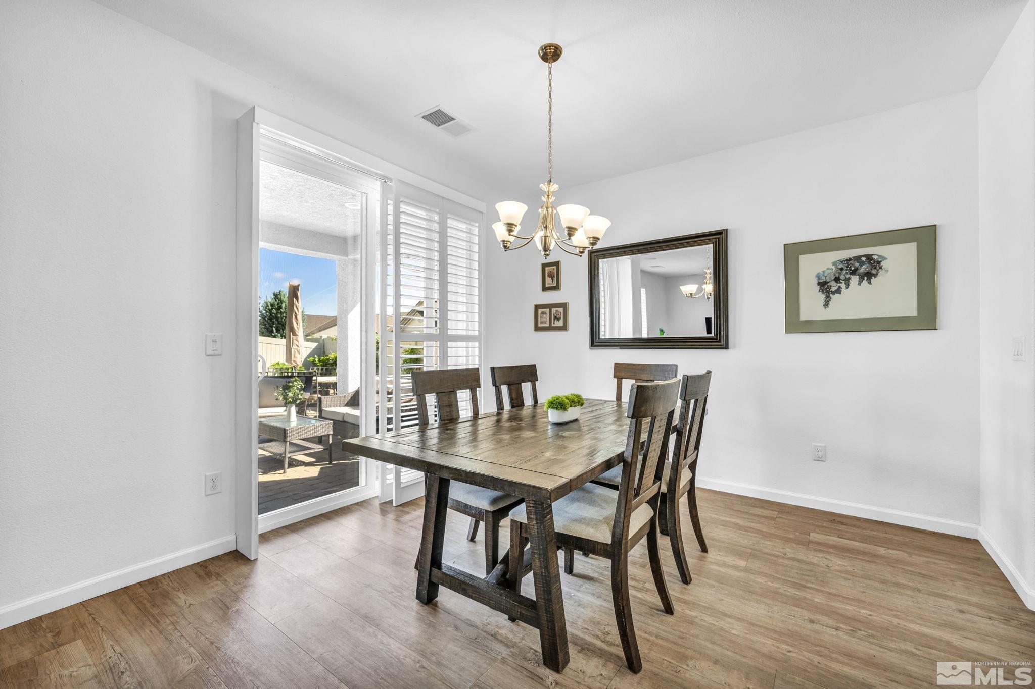 2197 Berkich Court Reno, NV 89521 - Photo 9 of 40 a dining room with furniture a chandelier and wooden floor