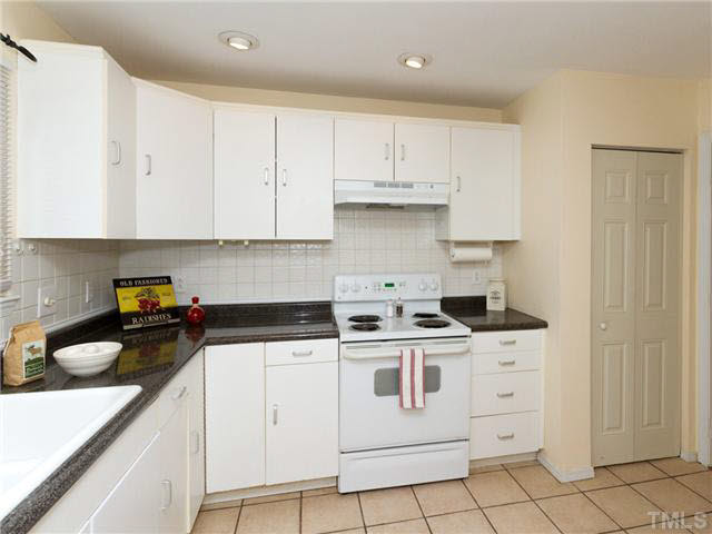 1330 Springlawn Court Raleigh, NC 27609 - Photo 6 of 19 a kitchen with granite countertop white cabinets and white appliances