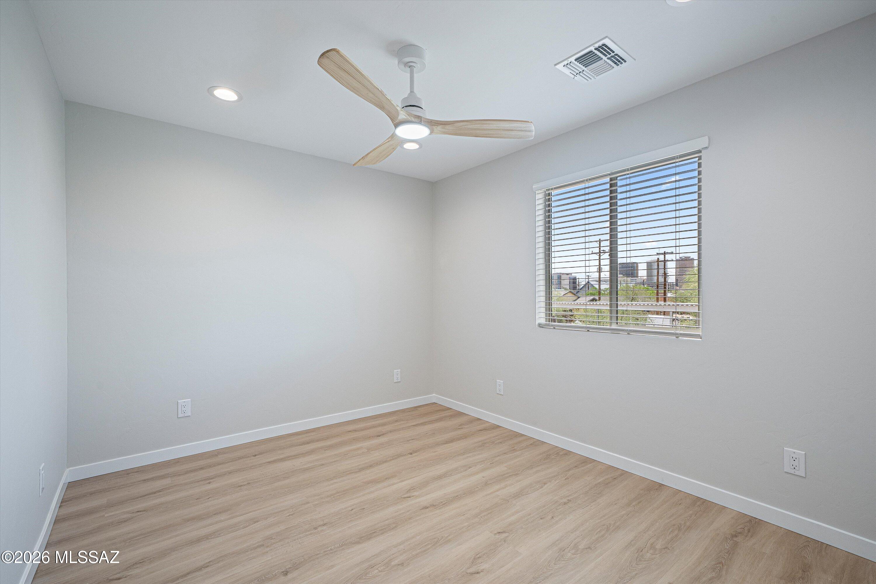 739 North Queen Avenue, Unit 2 Tucson, AZ 85705 - Photo 12 of 28 an empty room with wooden floor and windows
