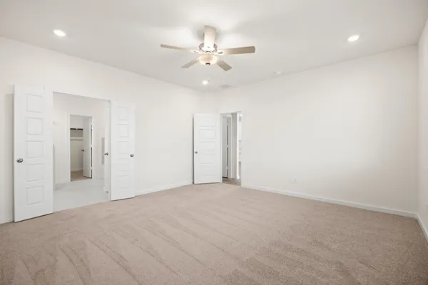 an empty room with a ceiling fan and a bathroom