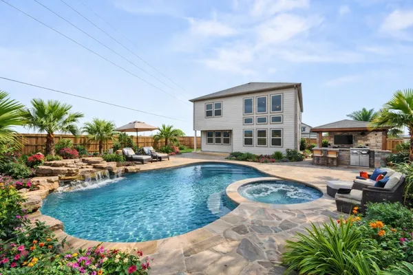 a view of a house with swimming pool and sitting area