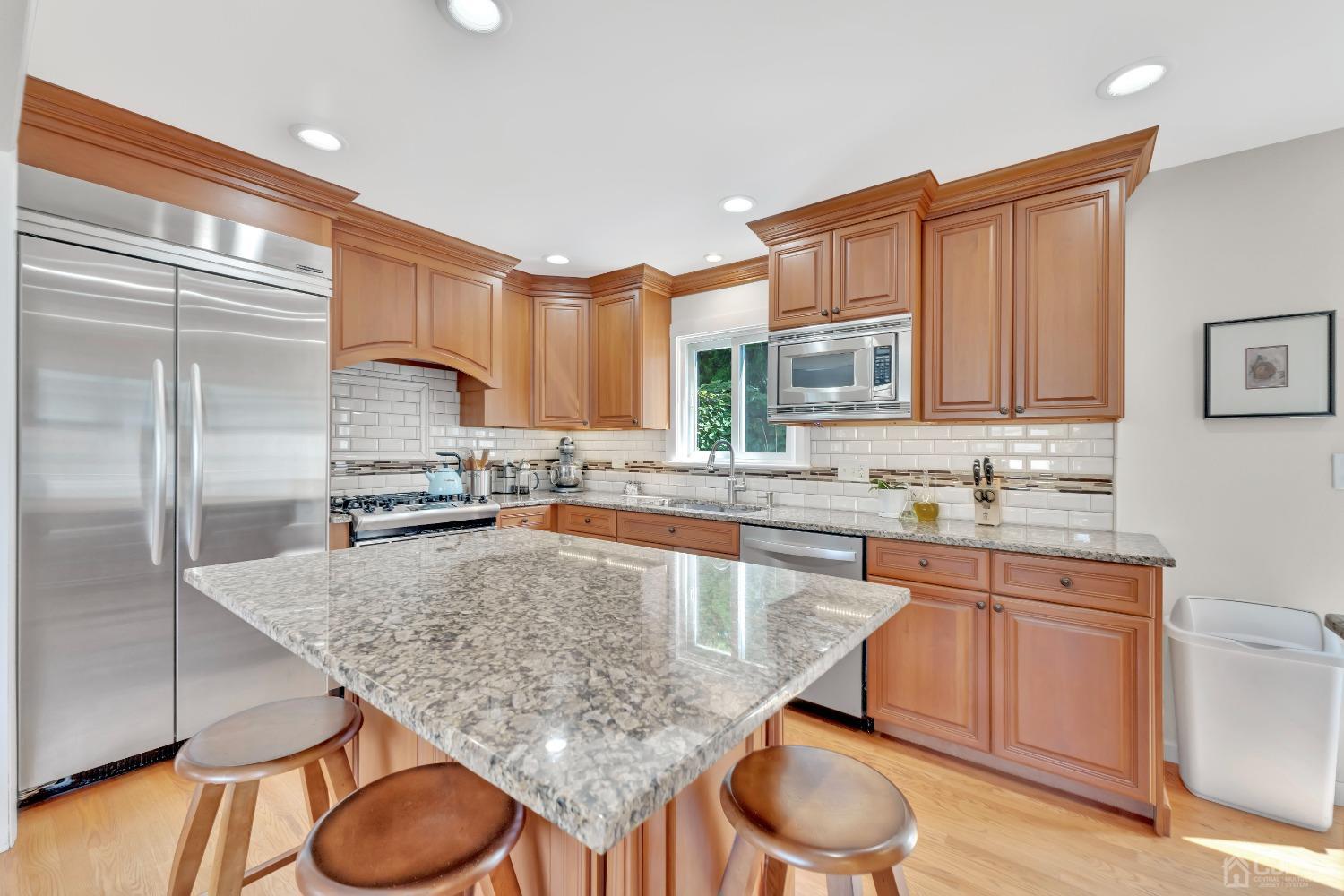 3237 Banta Road South Plainfield, NJ 07080 - Photo 9 of 26 a kitchen with kitchen island granite countertop a sink a center island and cabinets