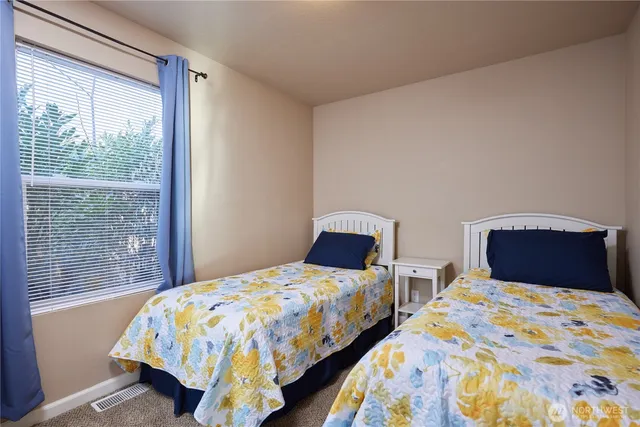 a bedroom with two beds and a window