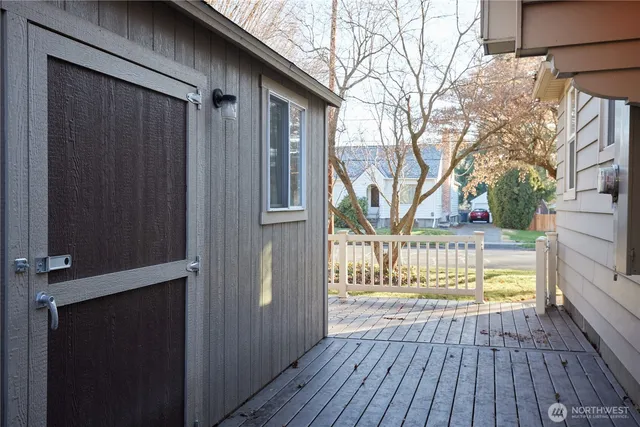 a view of a house with a tree and wooden fence