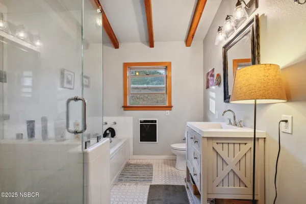 a bathroom with a granite countertop sink a mirror a vanity and a shower
