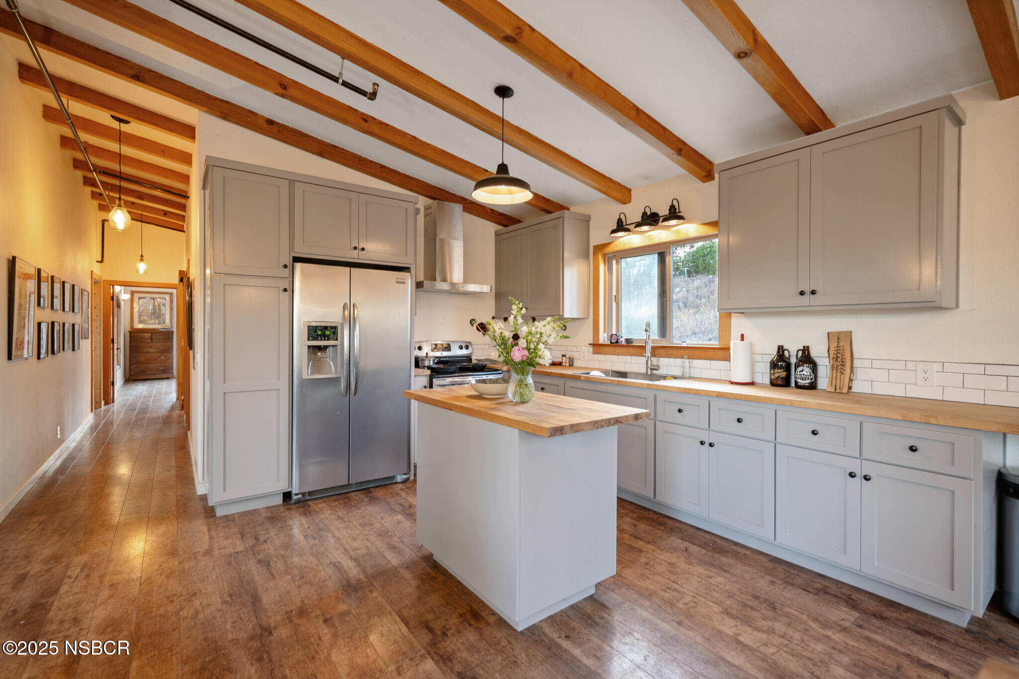 954 Ballard Canyon Road Solvang, CA 93463 - Photo 5 of 17 a kitchen with stainless steel appliances granite countertop a refrigerator a sink dishwasher a stove and white countertops with wooden floor