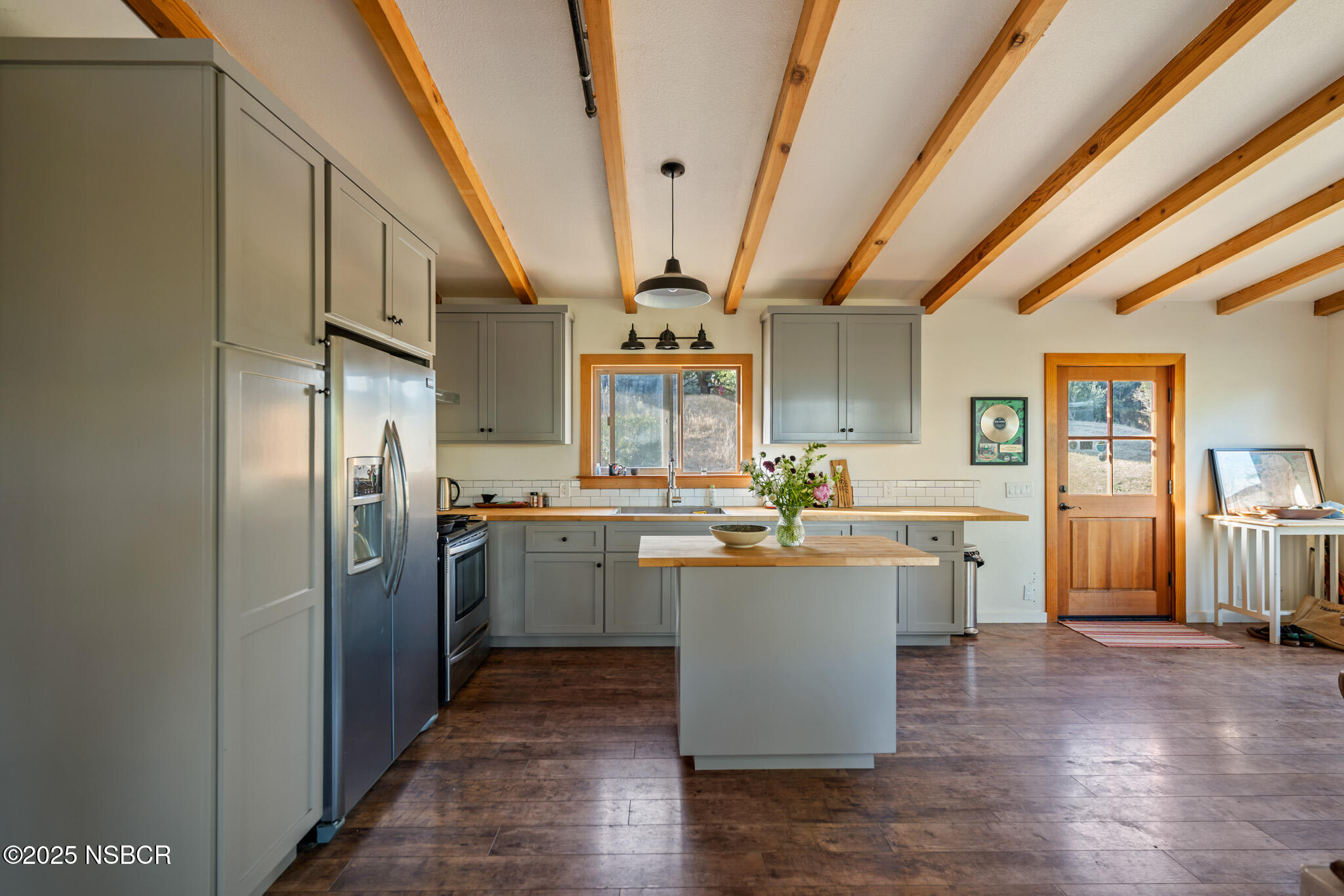 954 Ballard Canyon Road Solvang, CA 93463 - Photo 7 of 17 a kitchen with stainless steel appliances granite countertop a refrigerator a sink dishwasher a stove and white countertops with wooden floor