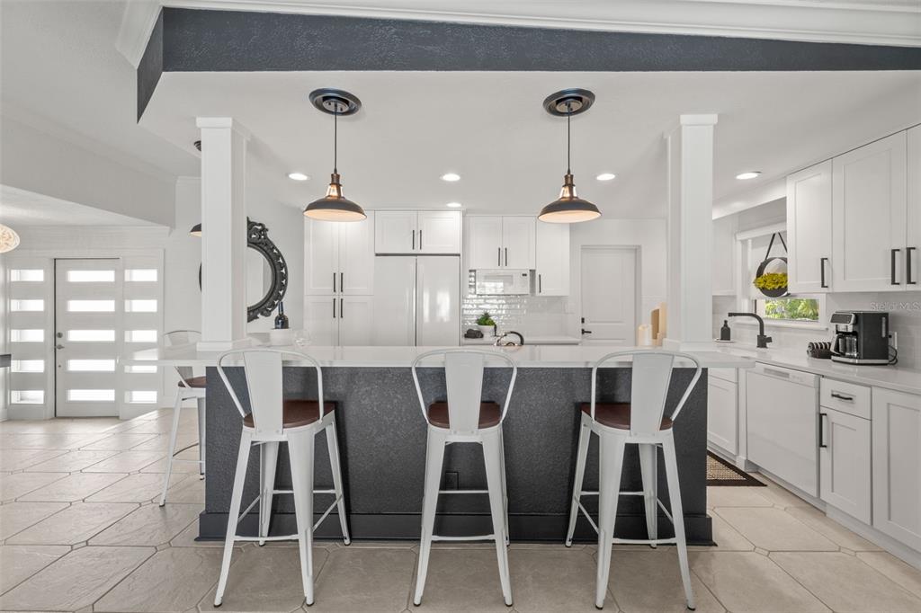 402 161st Avenue Redington Beach, FL 33708 - Photo 17 of 55 a large kitchen with a dining table chairs sink and cabinets