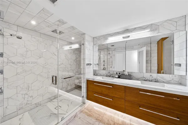 a bathroom with a double vanity sink mirror double and shower