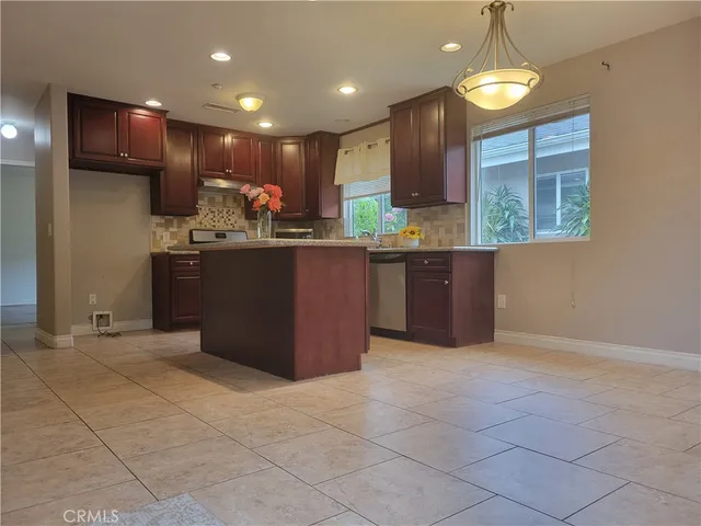 a kitchen with stainless steel appliances granite countertop a refrigerator and a stove top oven