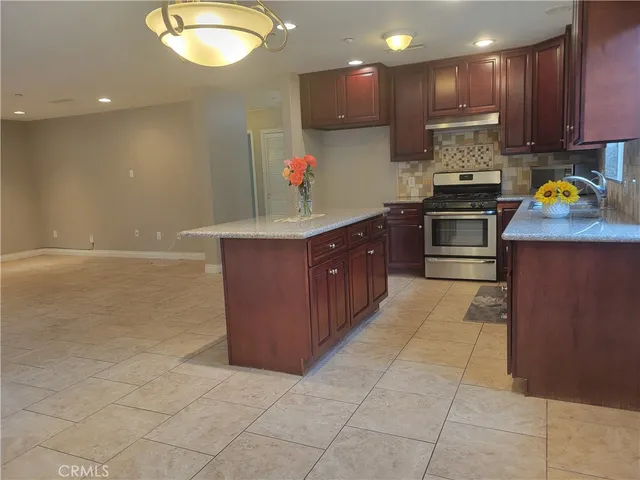 a kitchen with stainless steel appliances granite countertop a stove a sink and a refrigerator