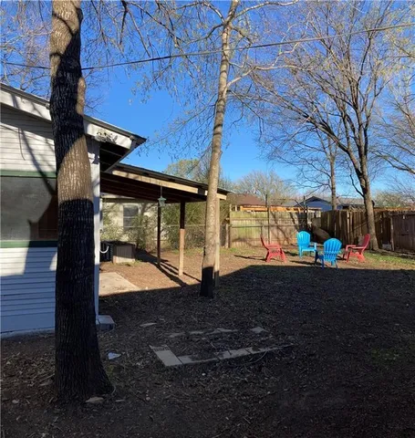 a view of a backyard with table and chairs and a fire pit