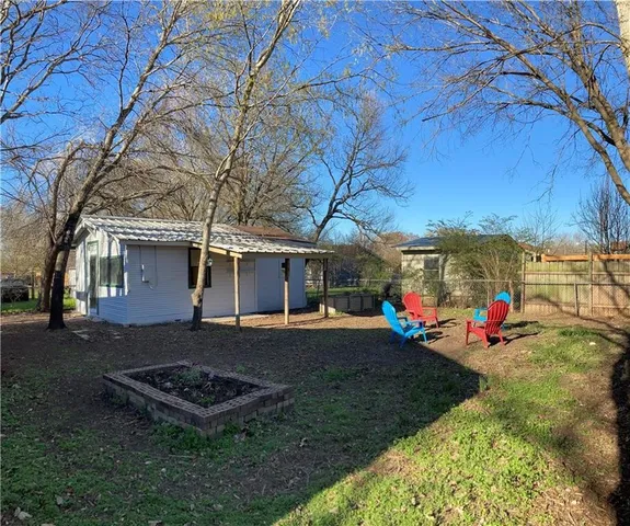 a backyard of a house with table and chairs